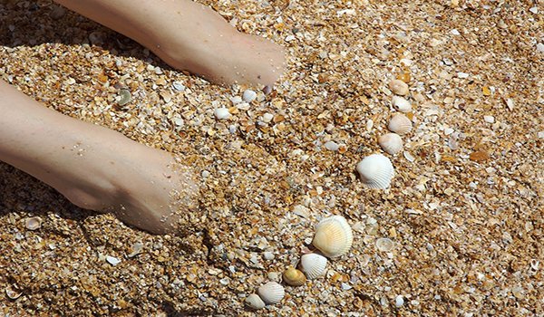 pies enterrados en arena del mar